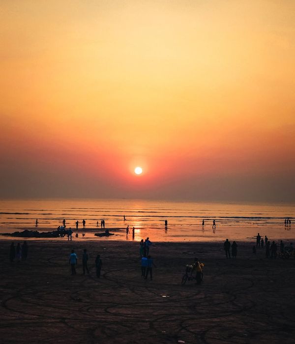 A calm person meditating outdoors with a serene natural background at sunrise.